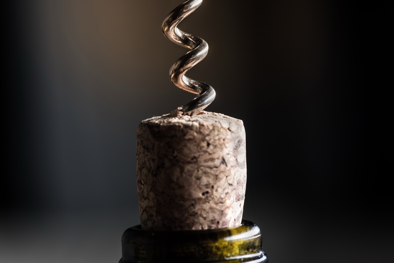 close up view of wine bottle with corkscrew with copy space