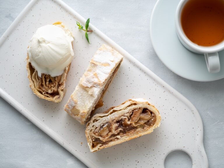 Apple strudel with ice cream and cinnamon. Baked cake and tea, delicious dessert on the table. Top view